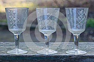 a row of white old three glass crystal goblets