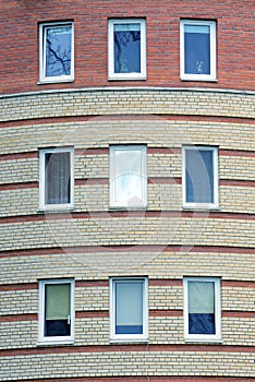 a row of white rectangular windows on a brown brick wall