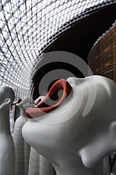 Row of white sculptures with red lips entitled 'Singing Sculptures' seen in a grand national