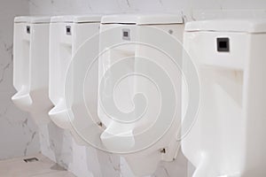 Row of white urinals in the men\'s bathroom, White ceramic urinals in public toilet