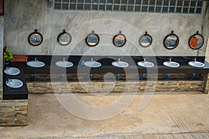 Row of white wash basins in the bathroom with row of mirrors in