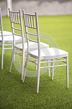 Row of white wedding chairs