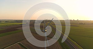 Row of Wind Turbine Blades Briefly Turning Perfectly in Sync During Sunset - Friesland, The Netherlands, 4K Drone Footage