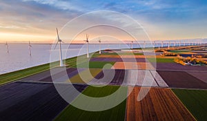 A row of wind turbines seen from above in a field under a cloudy sky