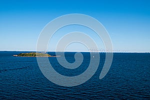 Row of wind turbines and a small island in Baltic Sea between Ge