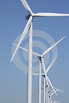 A row of windmills against a blue sky