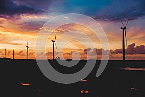 A row of windmills during a dramatic sundown in Bangui, Ilocos Norte, Philippines. Sustainable and renewable energy in Asia