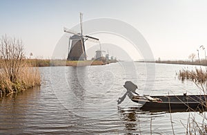 Row of windmills and a small boat