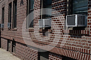 Row of Window Air Conditioners Outside an Old Brick Apartment Building in Astoria Queens New York