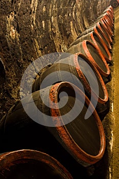 Row of Wine barrels in winery cellar recedes into