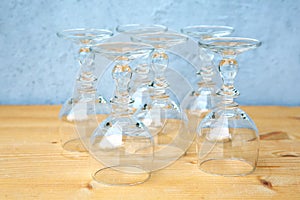 Row of wine glasses on wooden table with grey background