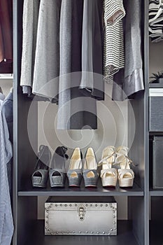 Row of women`s shoes on black wooden shelf