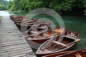 Row of wooden boats near a jetty on the lake