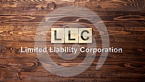 A row of wooden cubes with LLC text, the acronym of Limited Liability Company