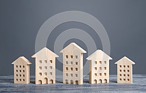 Row of wooden figures of residential buildings. Affordable comfortable housing. Search purchase best option apartment