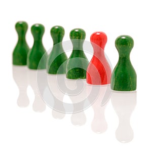 Row of wooden green figures and one red figure. Teamwork, balance and divercity concept