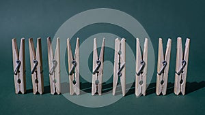 A row of wooden paper clips on a green background