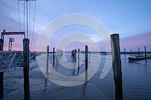 Row of wooden posts in the sea during twilight