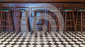 Row of wooden stools in front of green counter bar interior at the bar and pub, restuarant for drinking refresh relaxation in day