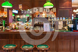 Row of wooden stools in front of green counter at the bar and pub, restuarant for drinking refresh relaxation in day life retro