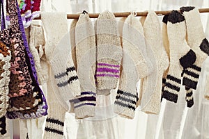 A row of wool knitted white socks . handmade work. the concept of zero waste. rustic style