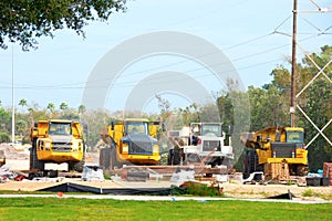 Row of working dump trucks parked in a row at construction zone site