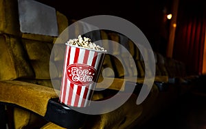 A row of yellow seat with popcorn on in theater