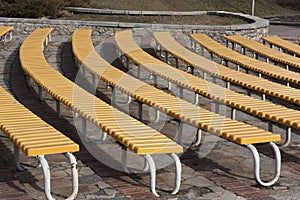 Row of yellow wooden seats on a spectator grandstand photo