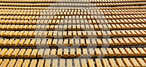 Row of yellow wooden seats on a spectator grandstand photo