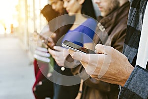 Row of Young Adults on their Smart Phones - Diversity - Communication - Eletronic Devices - Outdoors