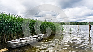 Rowboat tied to bollard in lake of Rheinsberg