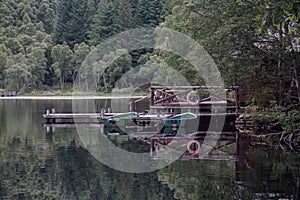 Rowboats tied to a dock by a the deck of a cabin