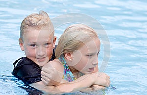 Rowdy Boy Holding Girl in Pool Water