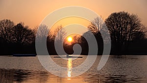 A rower on a lake in a dream sunset