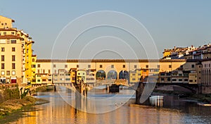 Rowers out on the River Arno during a lovely sunny morning in Florence, Italy, with the historic Ponte Vecchio in the background