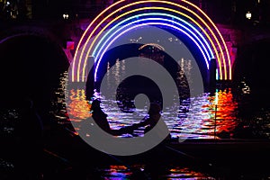 Rowers pass an artwork in a canal on the boat route Water Colors during the Amsterdam Light Festival