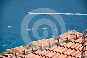 Rowers, sea, speedboat and red roofs