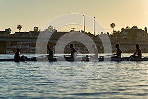 Rowers practicing teamwork at sunset