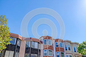 Rowhouses with bay windows against the clear sky in San Francisco, CA photo