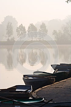 Rowing boats at misty pond