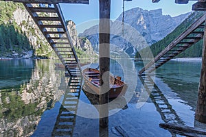 Rowing boats moored under a pair of wooden stairs in the Braies lake