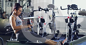 Rowing machine, woman and gym with fitness, workout and breathing in a health club. Female person, training and wellness