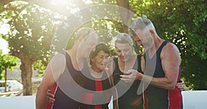 Rowing team of four senior caucasian men and women using smartphone