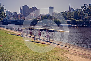 The rowing team prepare to start with their boat on the bank of Yarra river. 4PM, 25 February, 2017