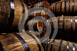 Rows of alcoholic drums in stock. Distillery. Cognac, whiskey, wine, brandy. Alcohol in barrels photo