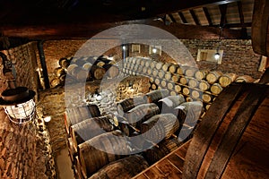 Rows of alcoholic drums in stock. Distillery. Cognac, whiskey, wine, brandy. Alcohol in barrels photo