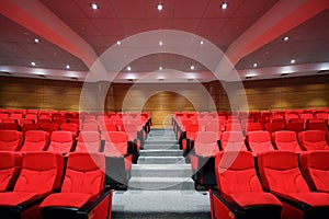 Rows of arm-chairs are in empty hall