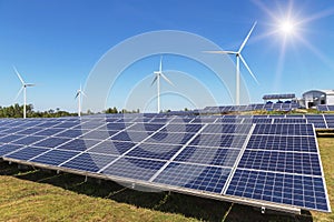 Rows array of polycrystalline silicon solar panels and wind turbines generating electricity in hybrid power plant systems station