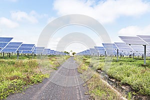 Rows array of polycrystalline silicon solar panels and wind turbines generating electricity in hybrid power plant systems station