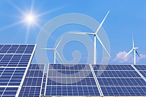 Rows array of polycrystalline silicon solar panels and wind turbines generating electricity in hybrid power plant systems station